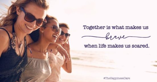 Group of beautiful young women strolling on a beach. Three friends walking on the beach and laughing on a summer day, enjoying vacation.